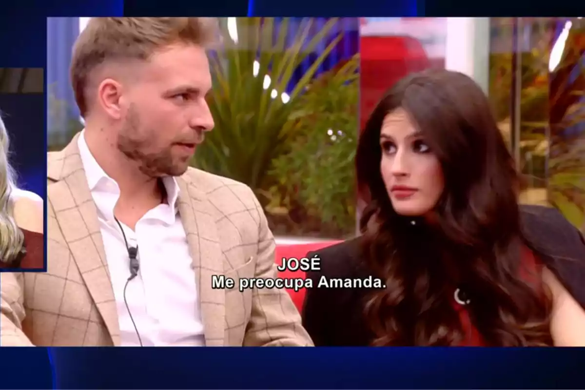 José María Almoguera y María Sánchez sentados en un sofá, el hombre lleva un traje claro y la mujer tiene el cabello largo y oscuro, en la pantalla se muestra un texto que dice "JOSÉ Me preocupa Amanda". Captura de ' GH Dúo'