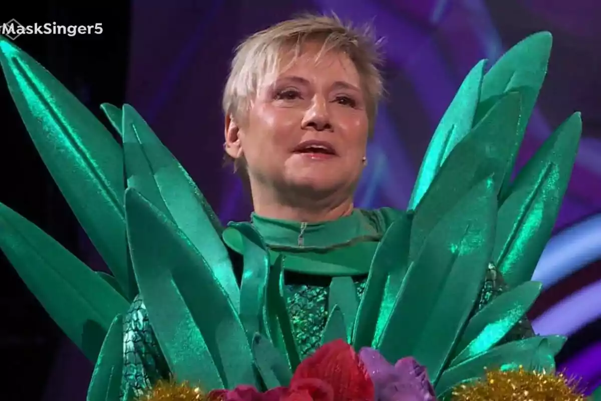 Gloria Serra con un disfraz de piña brillante con detalles en forma de hojas en un escenario de Mask Singer. Gloria Serra con un disfraz de piña brillante con detalles en forma de hojas en un escenario de Mask Singer.
