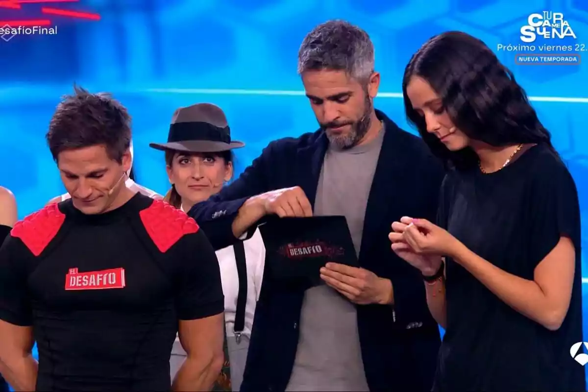 Gotzon Mantuliz, Roberto Leal, Victoria Federica y Susi Caramelo en un programa de televisión con un fondo azul y un cartel que dice "El Desafío".
