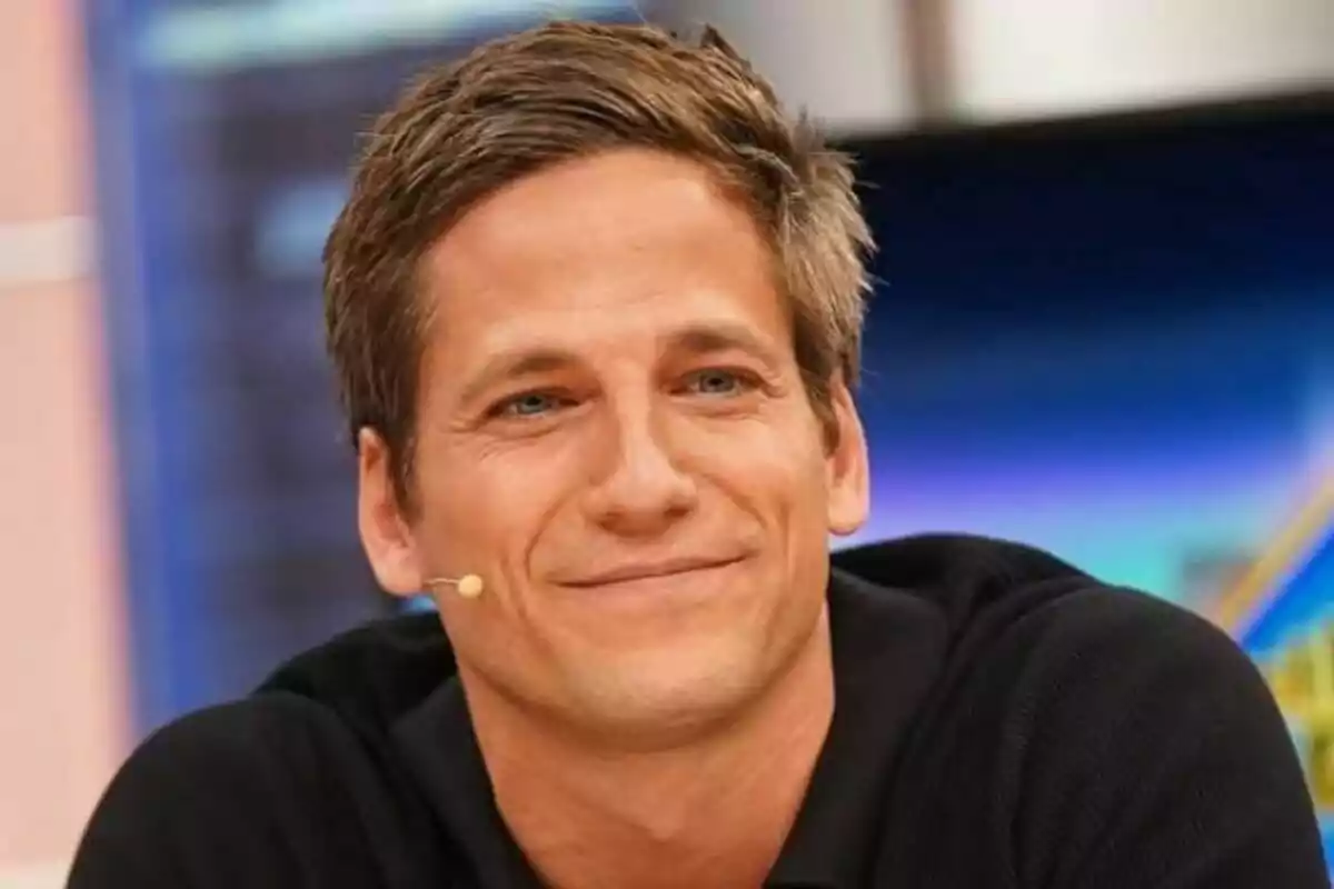 Gotzon Mantuliz sonriendo con micrófono en la oreja y fondo colorido en El Hormiguero.