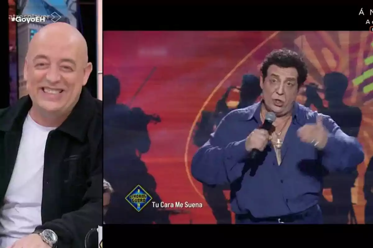 Goyo Jiménez sonriente está sentado a la izquierda mientras en la pantalla se muestra a otro hombre cantando con un micrófono en la mano, con el logo de "Tu Cara Me Suena" visible.