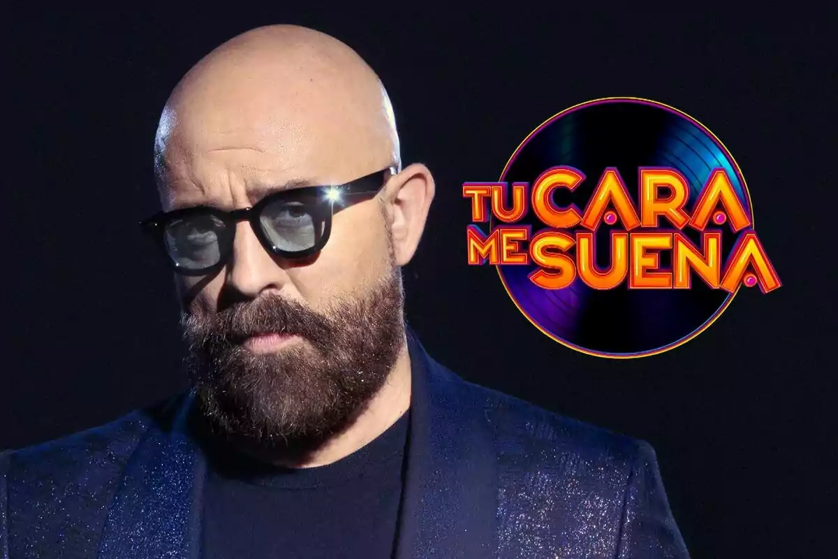 Goyo Jiménez con gafas de sol y barba junto al logo de "Tu Cara Me Suena".