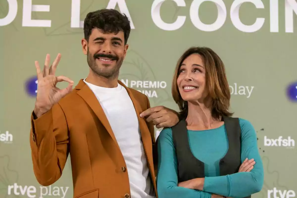 Germán González i Lydia Bosch posen davant d'una paret verda amb text, una fa un gest d' Germán González i Lydia Bosch posen davant d'una paret verda amb text, una fa un gest d'