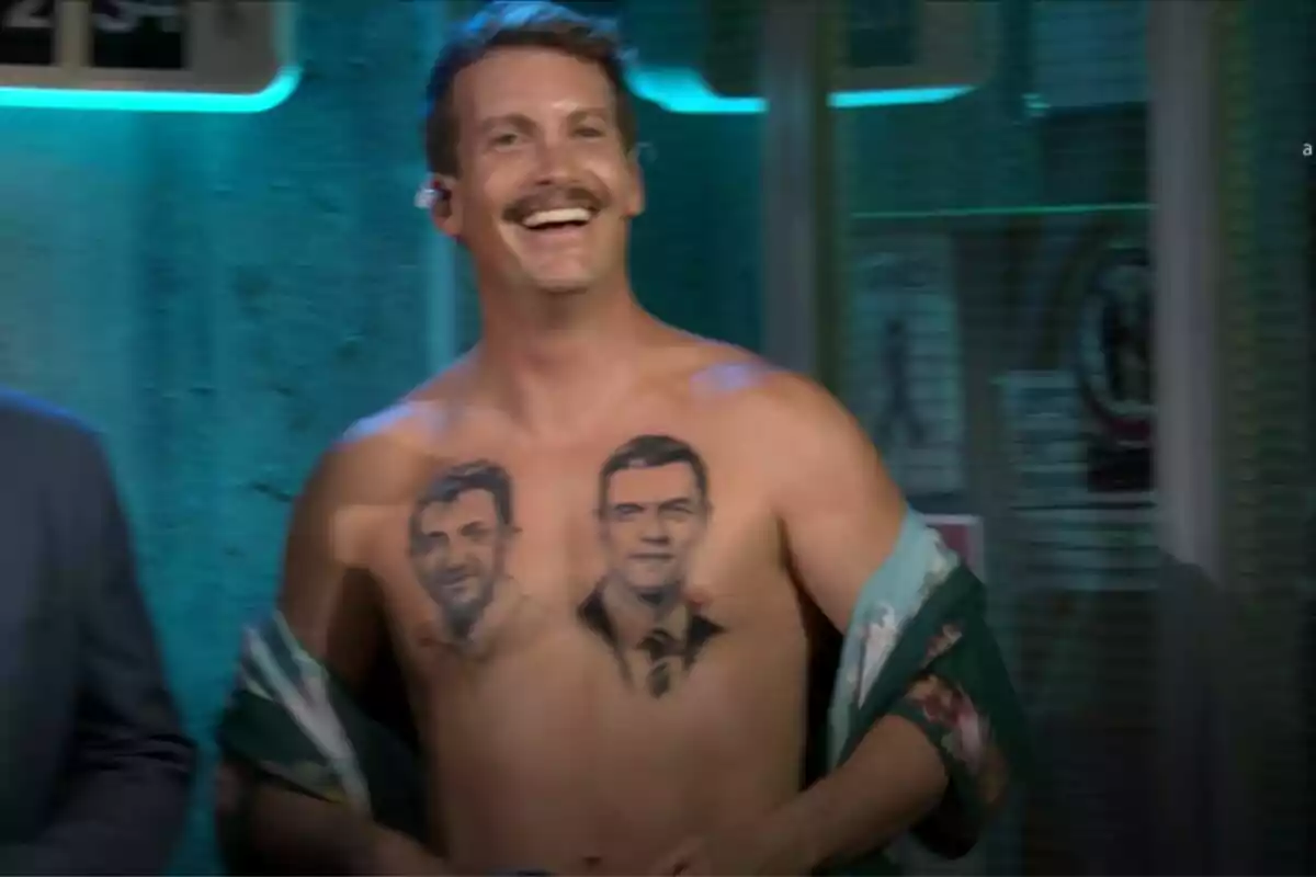 Grison sonriente con bigote en La Revuelta muestra su pecho desnudo, que tiene dos tatuajes de Pedro Sánchez y Pablo Motos Grison sonriente con bigote en La Revuelta muestra su pecho desnudo, que tiene dos tatuajes de Pedro Sánchez y Pablo Motos