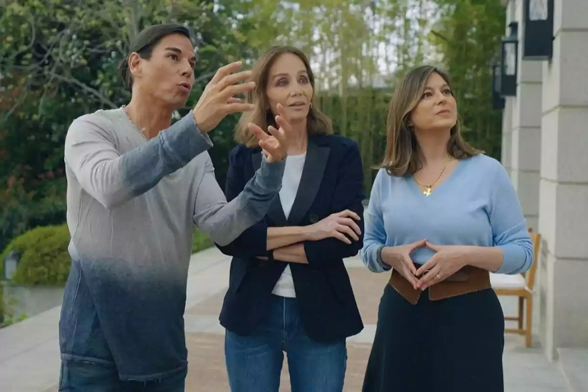 Fotografia de Chábeli i Julio Iglesias Jr al costat d'Isabel Preysler a l'aire lliure, una gesticulant amb les mans mentre les altres dues observen atentament a Los Iglesias: Germans a l'obra Fotografia de Chábeli i Julio Iglesias Jr al costat d'Isabel Preysler a l'aire lliure, una gesticulant amb les mans mentre les altres dues observen atentament a Los Iglesias: Germans a l'obra