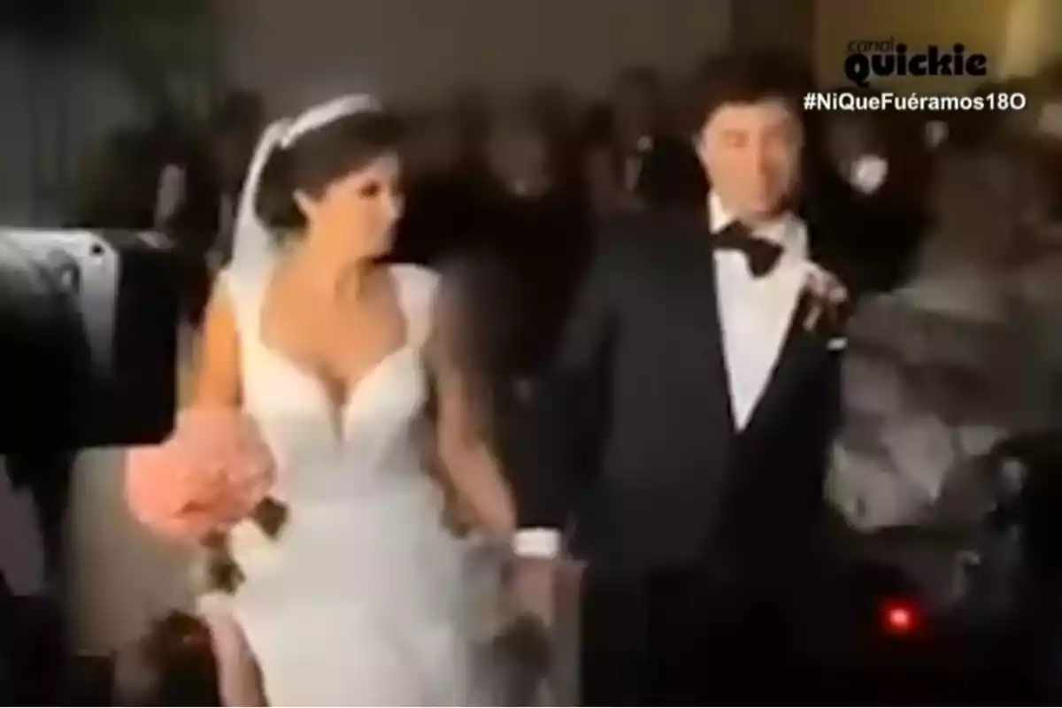 Una parella vestida de Novios camina de la mà en un esdeveniment formal. Una parella vestida de Novios camina de la mà en un esdeveniment formal.