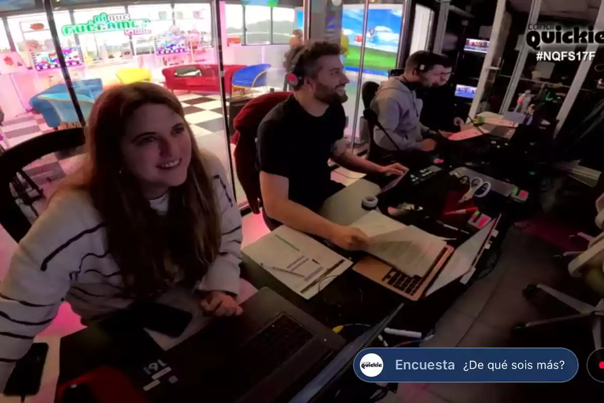 Un grupo de personas trabaja en una cabina de control con computadoras y auriculares, mientras observan pantallas y documentos. Un grupo de personas trabaja en una cabina de control con computadoras y auriculares, mientras observan pantallas y documentos.