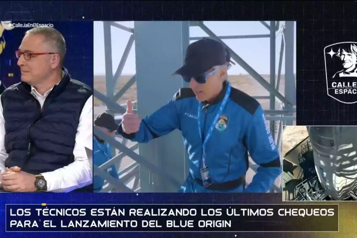 Un presentador de televisió conversa mentre es mostra Jesús Calleja amb vestit blau fent preparatius per al llançament del Blue Origin. Un presentador de televisió conversa mentre es mostra Jesús Calleja amb vestit blau fent preparatius per al llançament del Blue Origin.