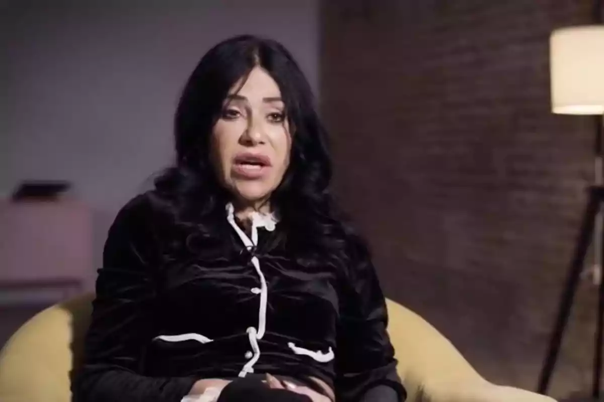 Maite Galdeano de cabello oscuro sentada en una silla amarilla con una pared de ladrillo y una lámpara de pie en el fondo. Maite Galdeano de cabello oscuro sentada en una silla amarilla con una pared de ladrillo y una lámpara de pie en el fondo.
