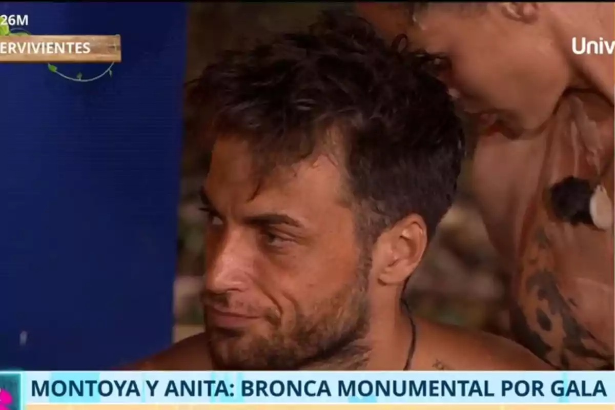 Montoya con expresión seria está sentado mientras una mujer se inclina hacia él en un entorno que parece ser un programa de televisión de supervivencia. Montoya con expresión seria está sentado mientras una mujer se inclina hacia él en un entorno que parece ser un programa de televisión de supervivencia.