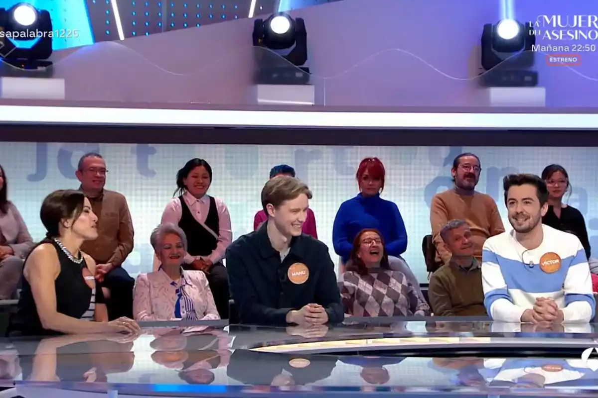 Un grupo de personas participa en un programa de televisión, sentados detrás de una mesa en un estudio con público en el fondo. Un grupo de personas participa en un programa de televisión, sentados detrás de una mesa en un estudio con público en el fondo.