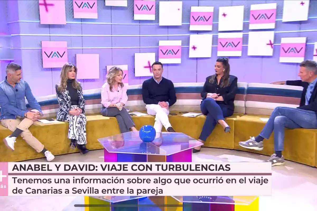 Un grupo de personas está sentado en 'Vamos a ver' con un diseño moderno y colorido, mientras en la parte inferior de la imagen se muestra un texto que menciona un viaje con turbulencias entre Anabel y David. Un grupo de personas está sentado en 'Vamos a ver' con un diseño moderno y colorido, mientras en la parte inferior de la imagen se muestra un texto que menciona un viaje con turbulencias entre Anabel y David.