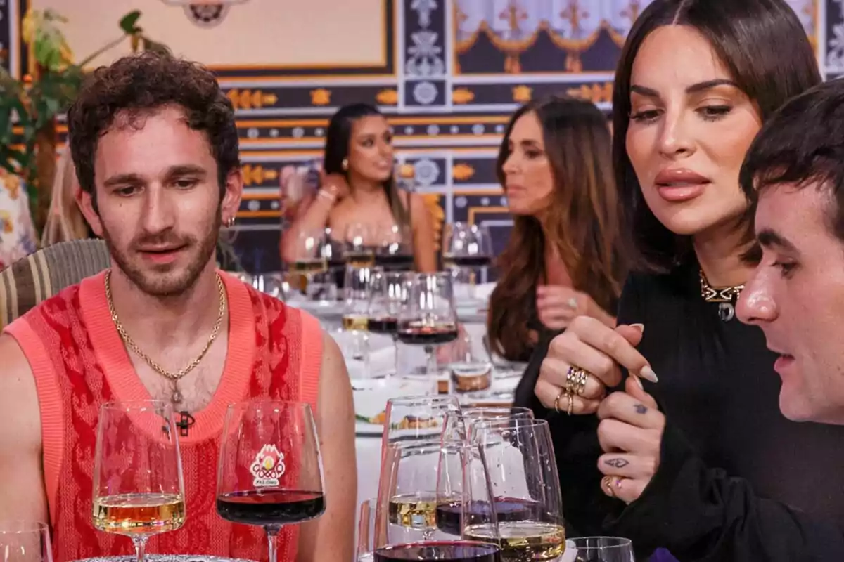 David Castillo, Jedet y Palomo Spain en un primer plano con Isabel Rábago y Marta Díaz de fondo sentadas en una mesa disfrutando de una cena con copas de vino en MasterChef Celebrity. David Castillo, Jedet y Palomo Spain en un primer plano con Isabel Rábago y Marta Díaz de fondo sentadas en una mesa disfrutando de una cena con copas de vino en MasterChef Celebrity.