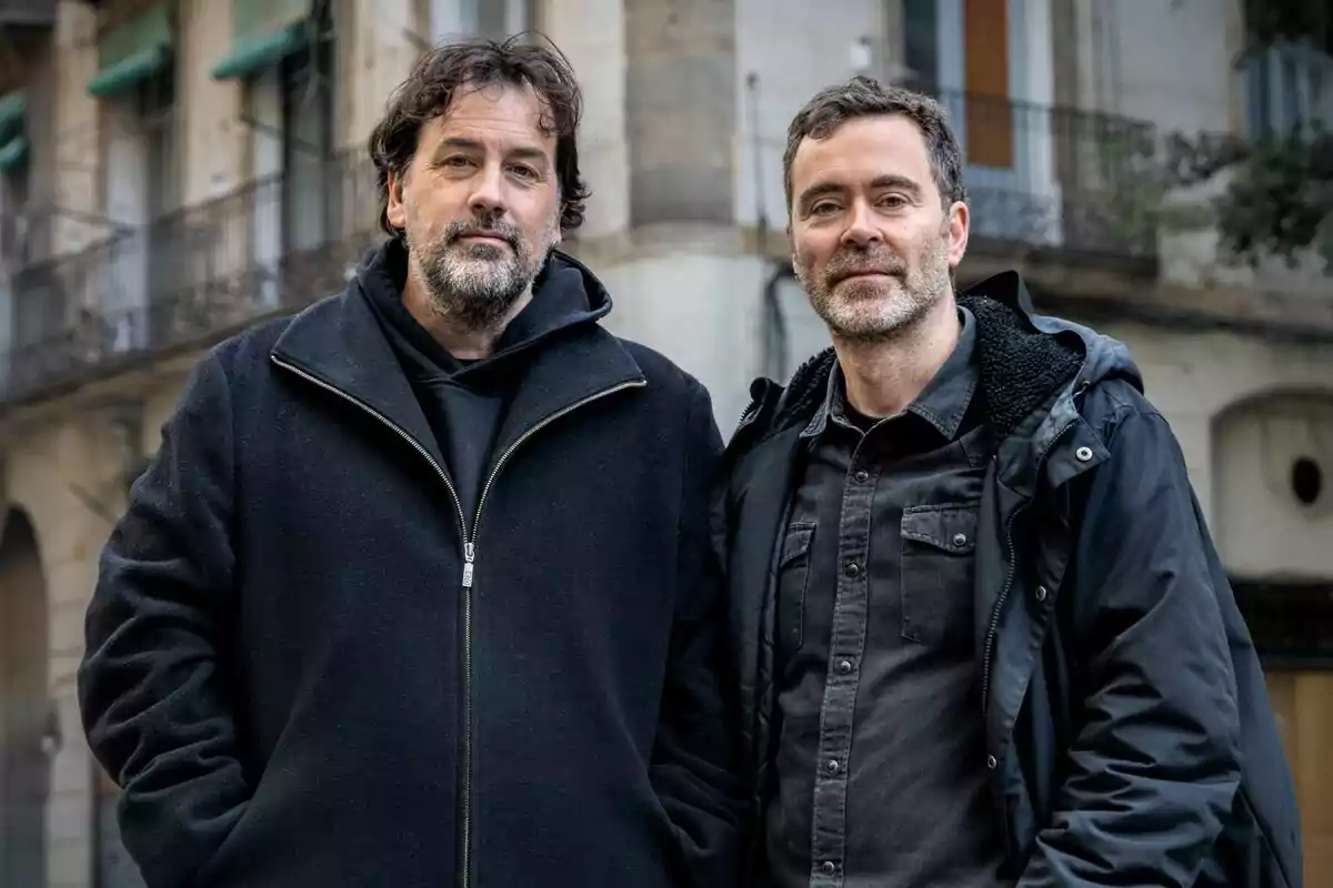 Pol Rodríguez i Isaki Lacuesta dempeus en un carrer amb edificis de fons.
