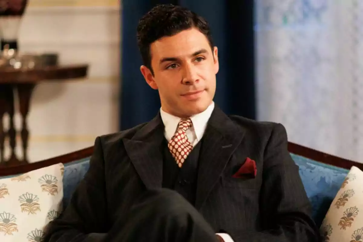 Pepe Nufrio con traje oscuro y corbata de lunares sentado en un sofá elegante en La Moderna. Pepe Nufrio con traje oscuro y corbata de lunares sentado en un sofá elegante en La Moderna.