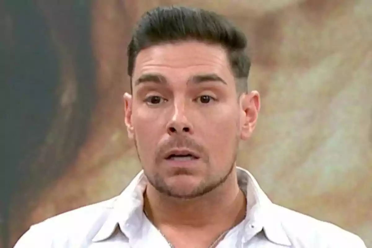 Primer plano de Jacobo Ostos con expresión de sorpresa y fondo desenfocado.