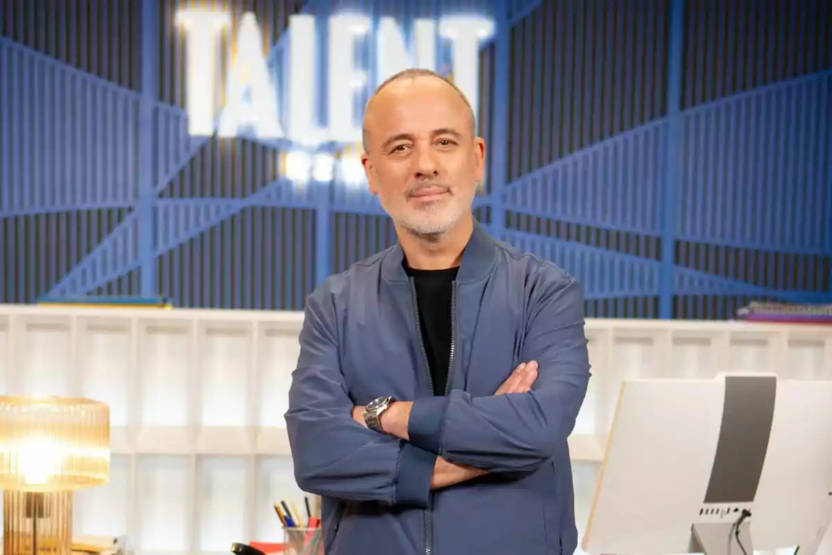 Javier Gutiérrez dret amb els braços creuats davant d'un fons que diu 