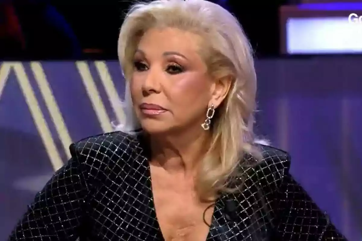 Jenny Llada con cabello rubio y maquillaje elegante usando un traje oscuro con detalles brillantes en De Viernes. Jenny Llada con cabello rubio y maquillaje elegante usando un traje oscuro con detalles brillantes en De Viernes.