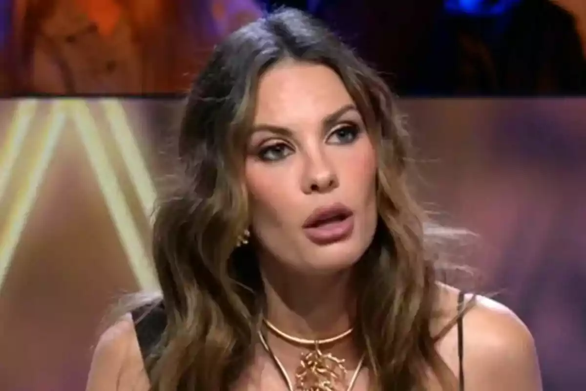Jessica Bueno con cabello largo y ondulado y expresión seria está en un entorno iluminado en De Viernes. Jessica Bueno con cabello largo y ondulado y expresión seria está en un entorno iluminado en De Viernes.