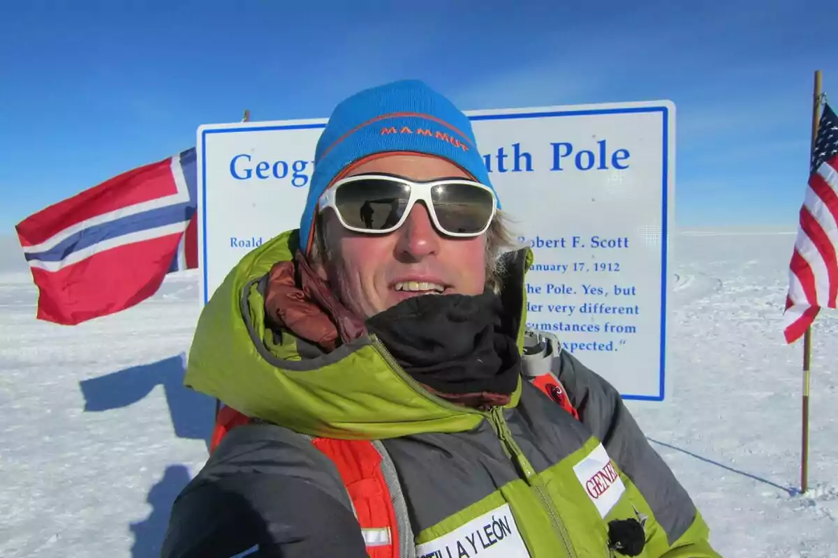 Jesús Calleja con ropa de abrigo y gafas de sol en el Polo Sur, con banderas de Noruega y Estados Unidos al fondo. Jesús Calleja con ropa de abrigo y gafas de sol en el Polo Sur, con banderas de Noruega y Estados Unidos al fondo.