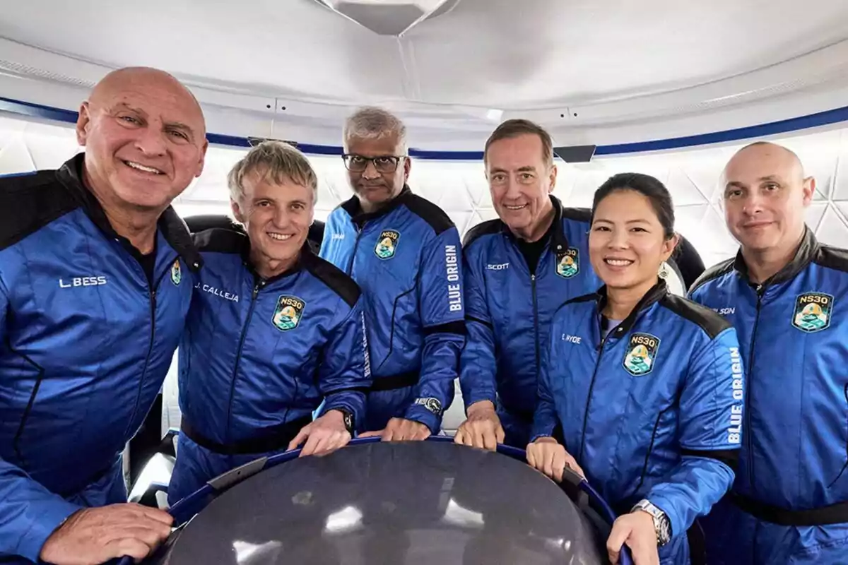 Un grup de persones com Jesús Calleja amb vestits espacials blaus de Blue Origin posant dins d'una càpsula. Un grup de persones com Jesús Calleja amb vestits espacials blaus de Blue Origin posant dins d'una càpsula.