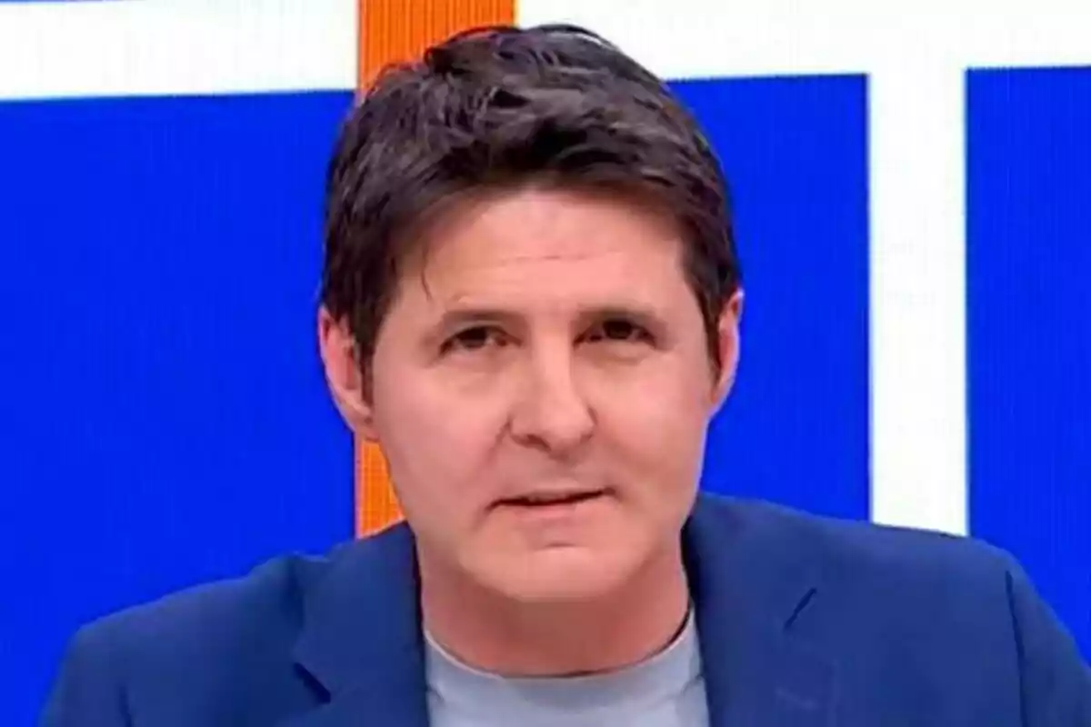 Jesús Cintora amb cabell fosc i jaqueta blava apareix davant d'un fons blau i blanc a Malas Lenguas.