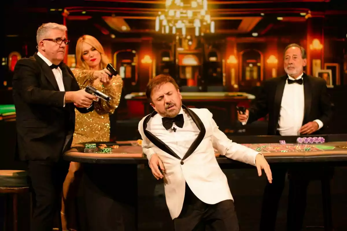 José Mota, Patricia Conde, Florentino Fernández y Guillermo Francella elegantemente vestidas en un casino, con dos de ellos apuntando con pistolas de juguete a un hombre que parece estar actuando dramáticamente en el programa 'José Mota No News'. José Mota, Patricia Conde, Florentino Fernández y Guillermo Francella elegantemente vestidas en un casino, con dos de ellos apuntando con pistolas de juguete a un hombre que parece estar actuando dramáticamente en el programa 'José Mota No News'.