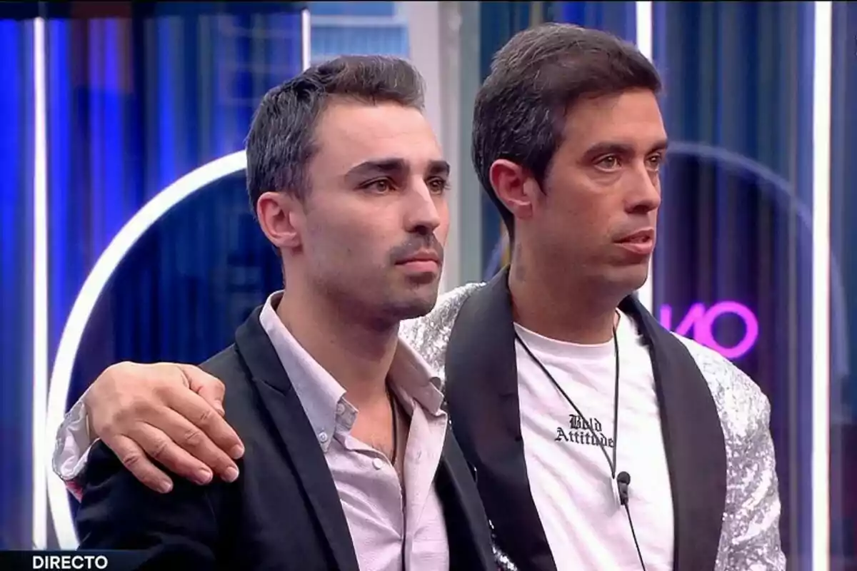 Jorge i Javier dret a la casa de Gran Hermano amb llums de neó al fons, un amb el braç sobre l'espatlla de l'altre. Jorge i Javier dret a la casa de Gran Hermano amb llums de neó al fons, un amb el braç sobre l'espatlla de l'altre.