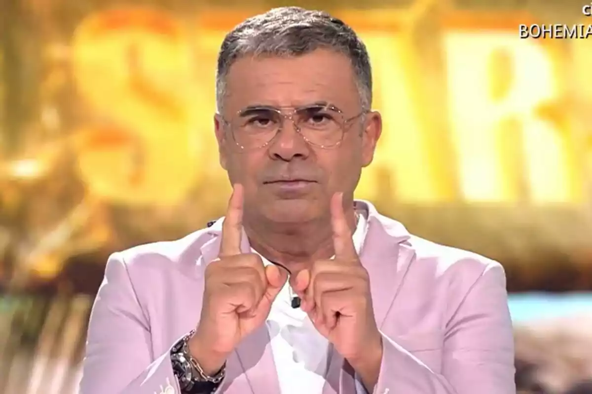 Jorge Javier Vázuqez amb una americana rosa pàl·lid i amb els dits aixecats presentant una gala de Supervivientes: All Stars Jorge Javier Vázuqez amb una americana rosa pàl·lid i amb els dits aixecats presentant una gala de Supervivientes: All Stars