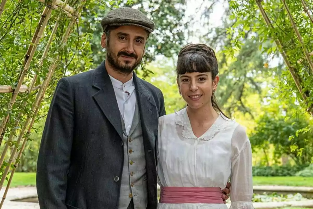Jorge Pobes i Victòria Llac vestits amb roba d'època posant en un jardí verd i frondós a La Promesa.