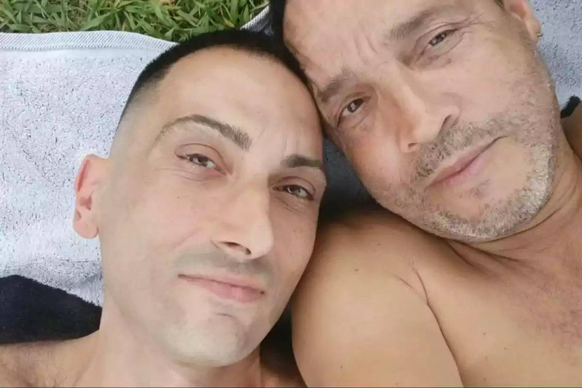 Juanma García junto a otro hombre recostados sobre una toalla en el césped, miran a la cámara. Juanma García junto a otro hombre recostados sobre una toalla en el césped, miran a la cámara.