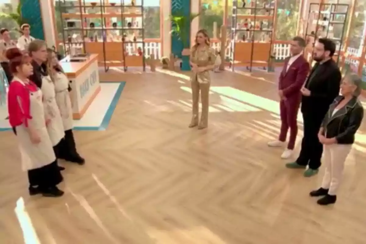 Yurena, Cristina Tárrega, Mark Vanderloo se encuentra en un set de cocina, con algunos vistiendo delantales y otros de pie al frente, mientras Paula Vázquez en el centro parece estar hablando o presentando. Yurena, Cristina Tárrega, Mark Vanderloo se encuentra en un set de cocina, con algunos vistiendo delantales y otros de pie al frente, mientras Paula Vázquez en el centro parece estar hablando o presentando.