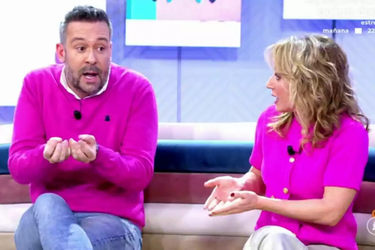 Sandra Aladro y Kike Calleja sentadas en un sofá, ambas vistiendo suéteres rosas, parecen estar conversando animadamente en Vamos a ver. Sandra Aladro y Kike Calleja sentadas en un sofá, ambas vistiendo suéteres rosas, parecen estar conversando animadamente en Vamos a ver.