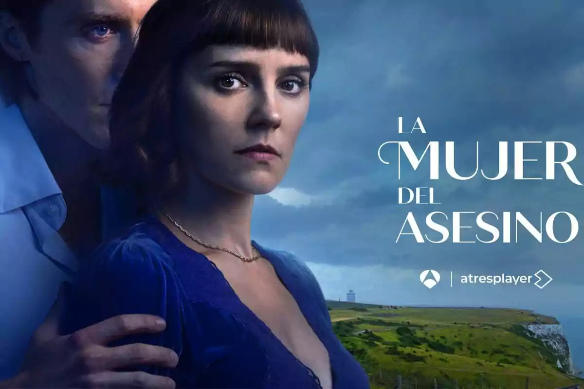 Una dona amb expressió seriosa és abraçada per un home en un paisatge costaner amb el text Una dona amb expressió seriosa és abraçada per un home en un paisatge costaner amb el text