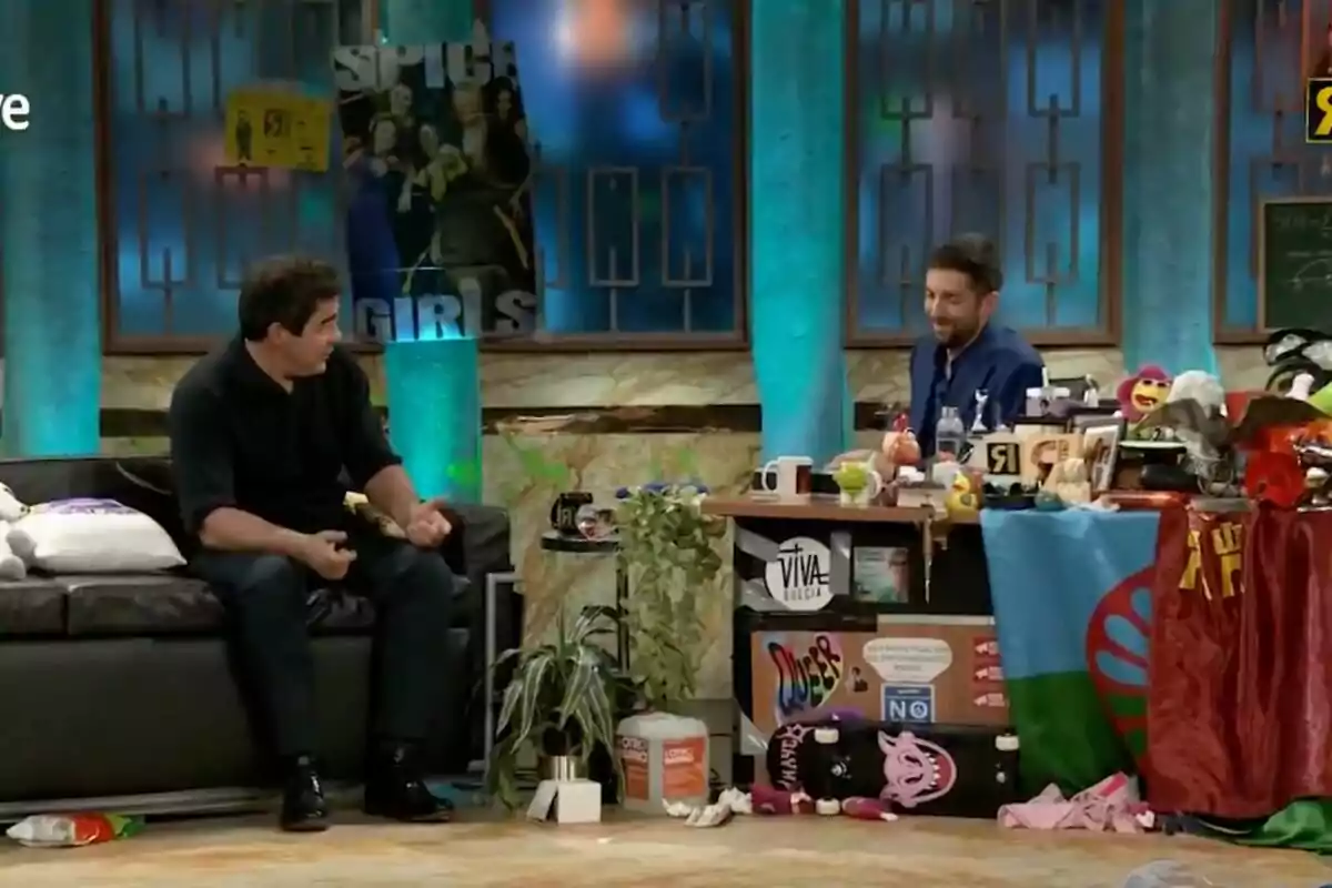 'La Revuelta' con David Broncano y Pablo Chiapella conversando en un set decorado con carteles y objetos variados. 'La Revuelta' con David Broncano y Pablo Chiapella conversando en un set decorado con carteles y objetos variados.