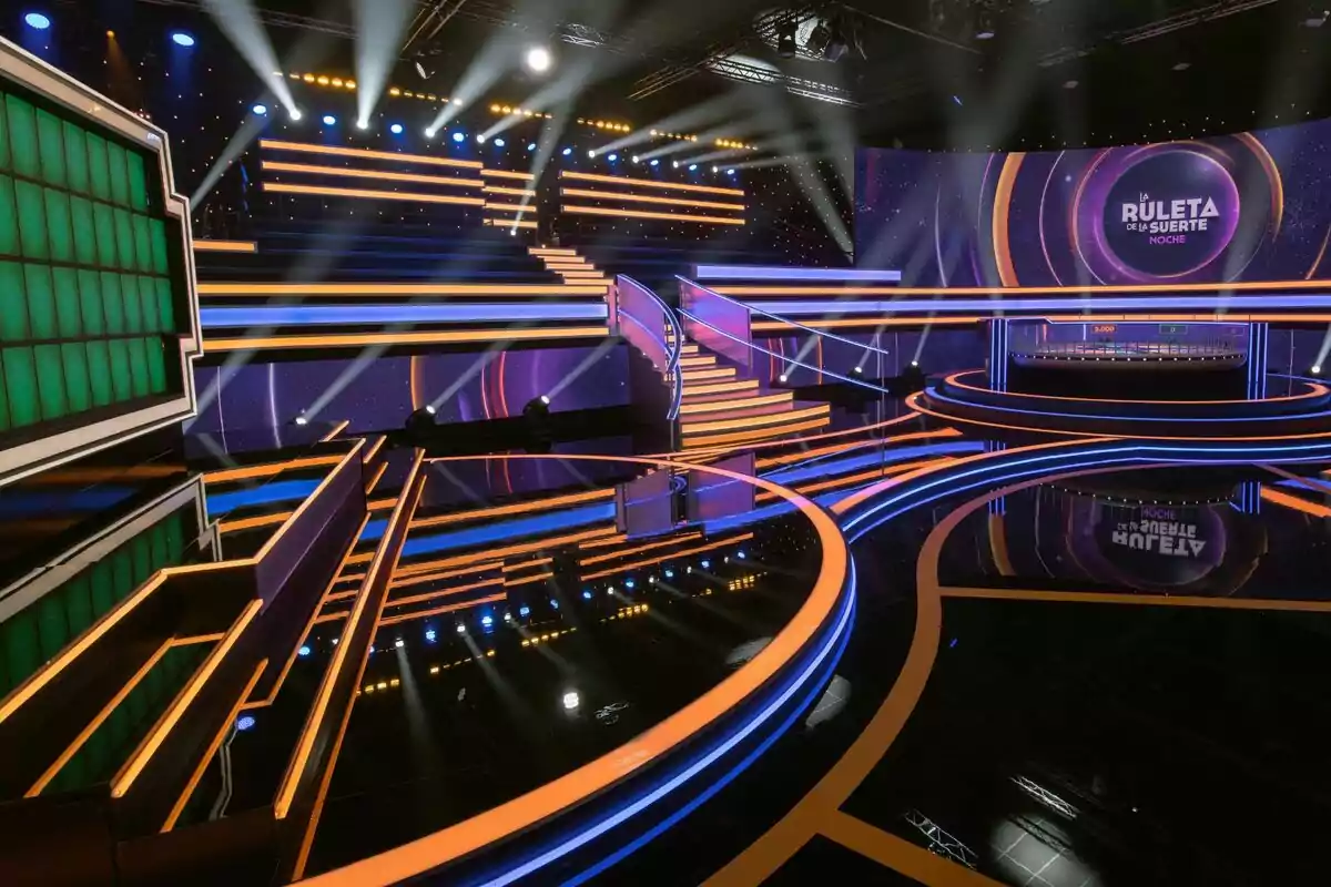 Escenario iluminado de un programa de televisión con una pantalla verde y un letrero que dice Escenario iluminado de un programa de televisión con una pantalla verde y un letrero que dice