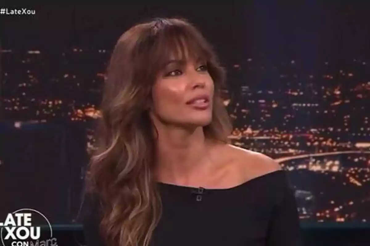 Lara Álvarez con cabello largo y ondulado en Late Xou con Marc Giró con un fondo de luces de ciudad. Lara Álvarez con cabello largo y ondulado en Late Xou con Marc Giró con un fondo de luces de ciudad.