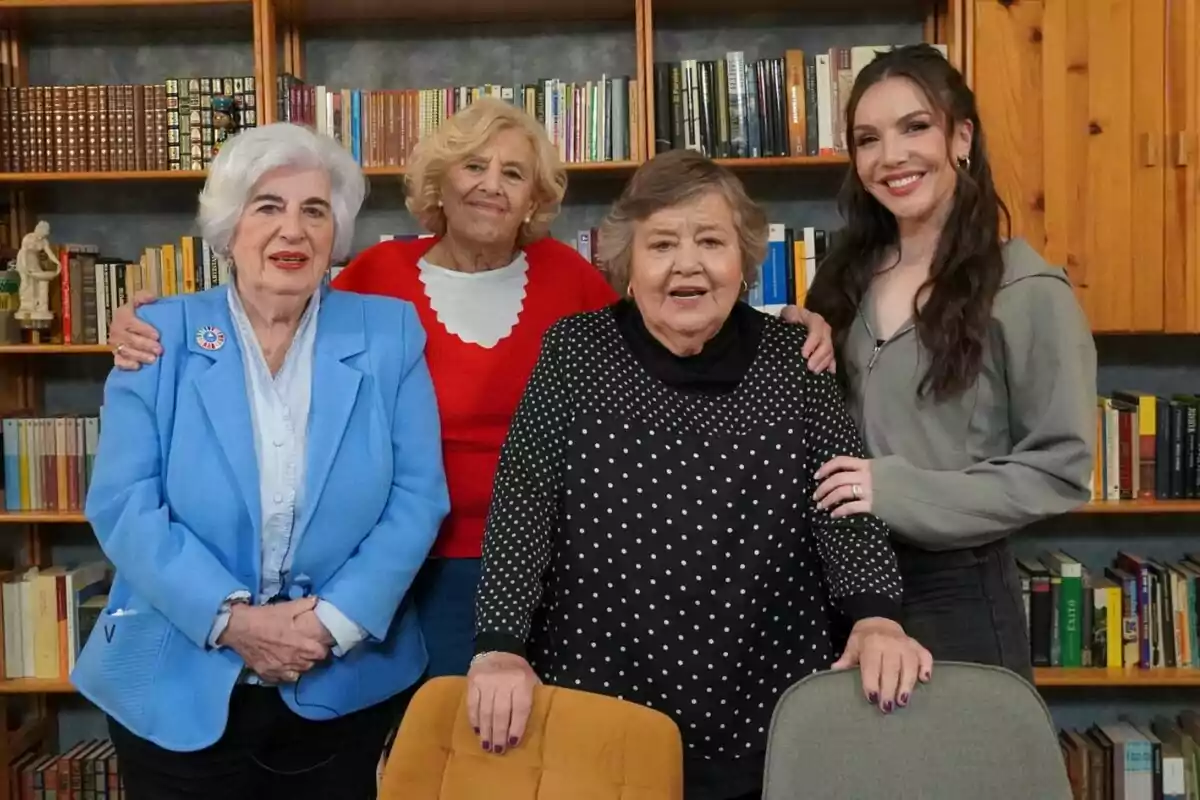 Manuela Carmena, Cristina Almeida, Paca Sauquillo e Inés Hernand posan juntas frente a una estantería llena de libros, mostrando una expresión amigable y sonriente en Las abogadas & compañía.