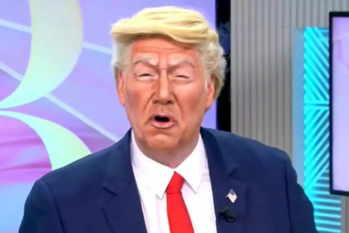 Carlos Latre disfressat de Donald Trump amb perruca rossa i maquillatge ataronjat porta un vestit fosc i corbata vermella a El Programa de Ana Rosa. Carlos Latre disfressat de Donald Trump amb perruca rossa i maquillatge ataronjat porta un vestit fosc i corbata vermella a El Programa de Ana Rosa.