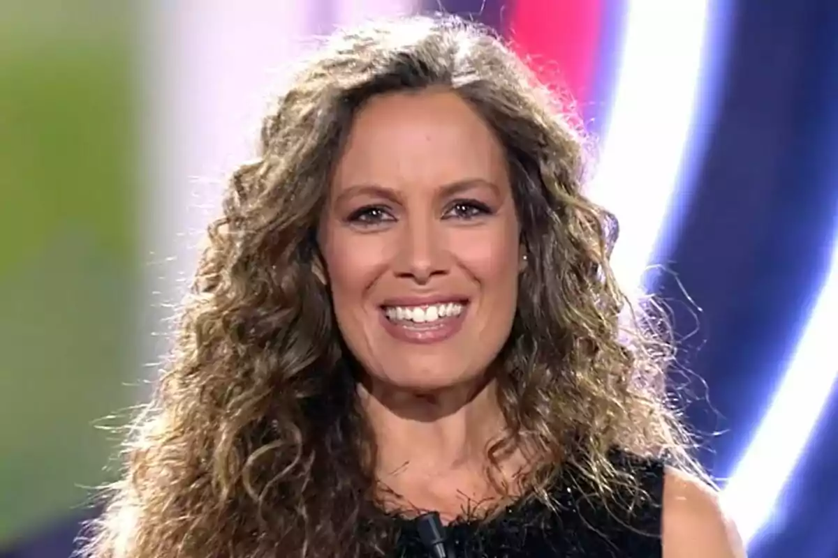 Laura Madrueño amb cabell arrissat i somriure en un entorn il·luminat al plató de Gran Hermano. Laura Madrueño amb cabell arrissat i somriure en un entorn il·luminat al plató de Gran Hermano.