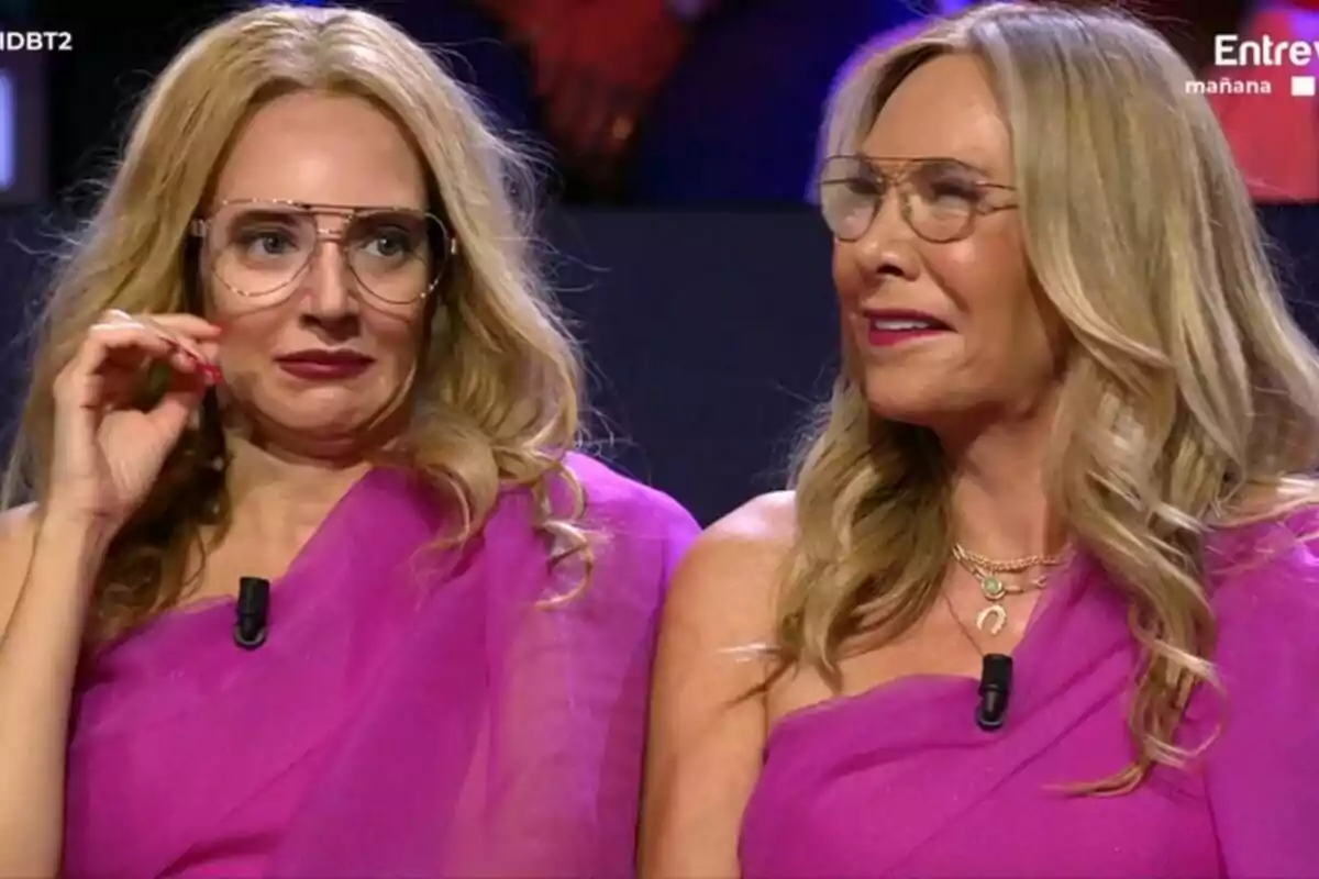 Belén Rodríguez juntament amb Leonor Lavado caracteritzada amb vestits i teles de color rosa, totes dues amb ulleres i cabell ros, estan assegudes una al costat de l'altra al plató de Gran Hermano. Belén Rodríguez juntament amb Leonor Lavado caracteritzada amb vestits i teles de color rosa, totes dues amb ulleres i cabell ros, estan assegudes una al costat de l'altra al plató de Gran Hermano.