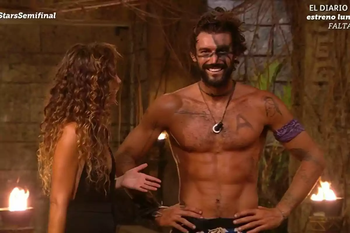 Captura de Laura Madrueño amb Logan Sampedro sense camisa amb pintura facial negra i diversos tatuatges a la palapa de Supervivientes