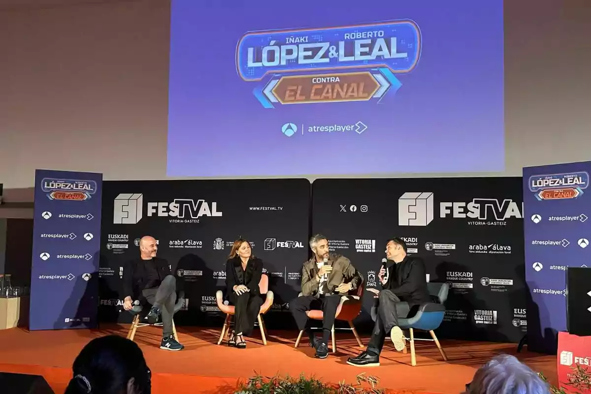 Roberto Leal, Iñaki López, Carmen Ferreiro y Edi Walter sentados en un escenario durante un evento del FesTVal en Vitoria-Gasteiz, con un cartel de Roberto Leal, Iñaki López, Carmen Ferreiro y Edi Walter sentados en un escenario durante un evento del FesTVal en Vitoria-Gasteiz, con un cartel de