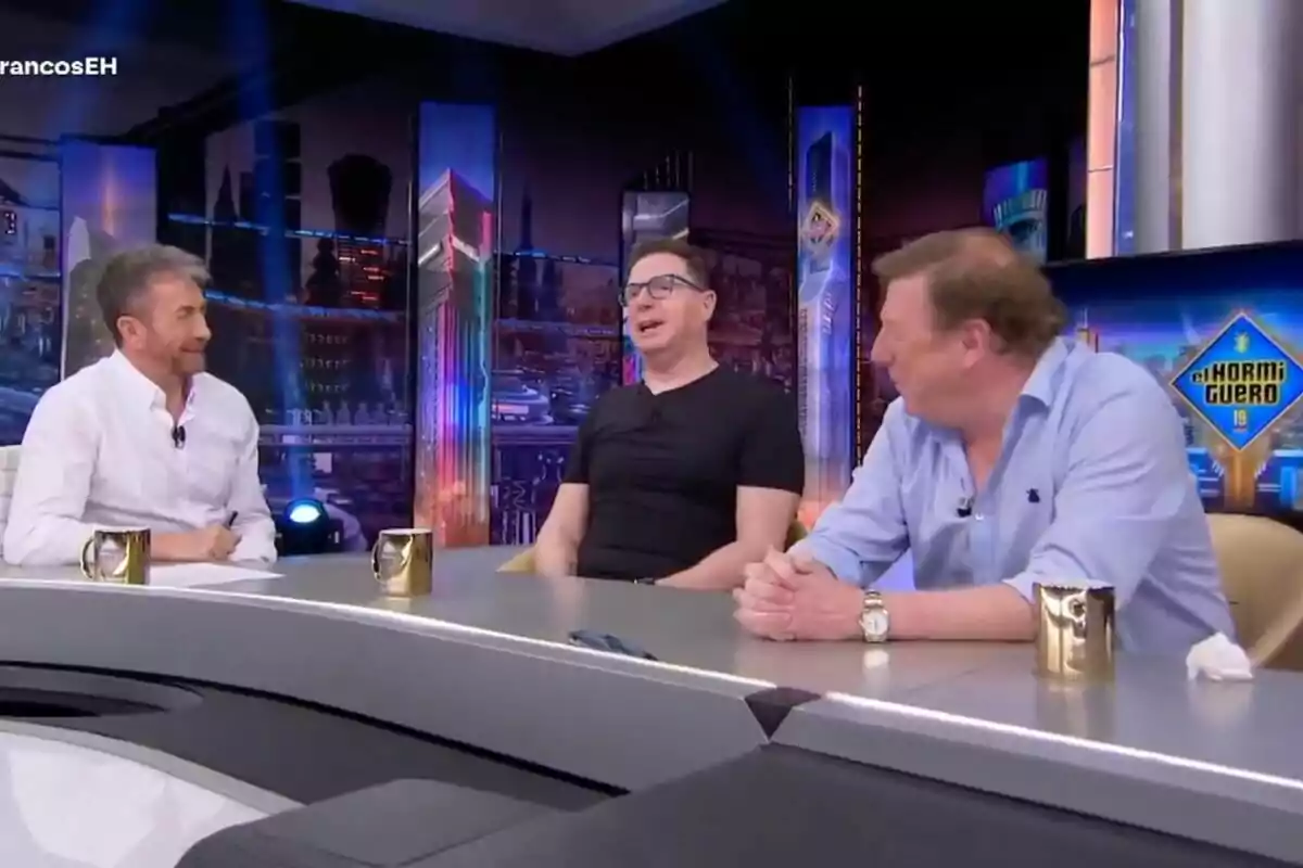 Pablo Motos y Los Morancos conversan en un set de televisión con un fondo colorido y tazas doradas sobre la mesa en 'El Hormiguero'. Pablo Motos y Los Morancos conversan en un set de televisión con un fondo colorido y tazas doradas sobre la mesa en 'El Hormiguero'.
