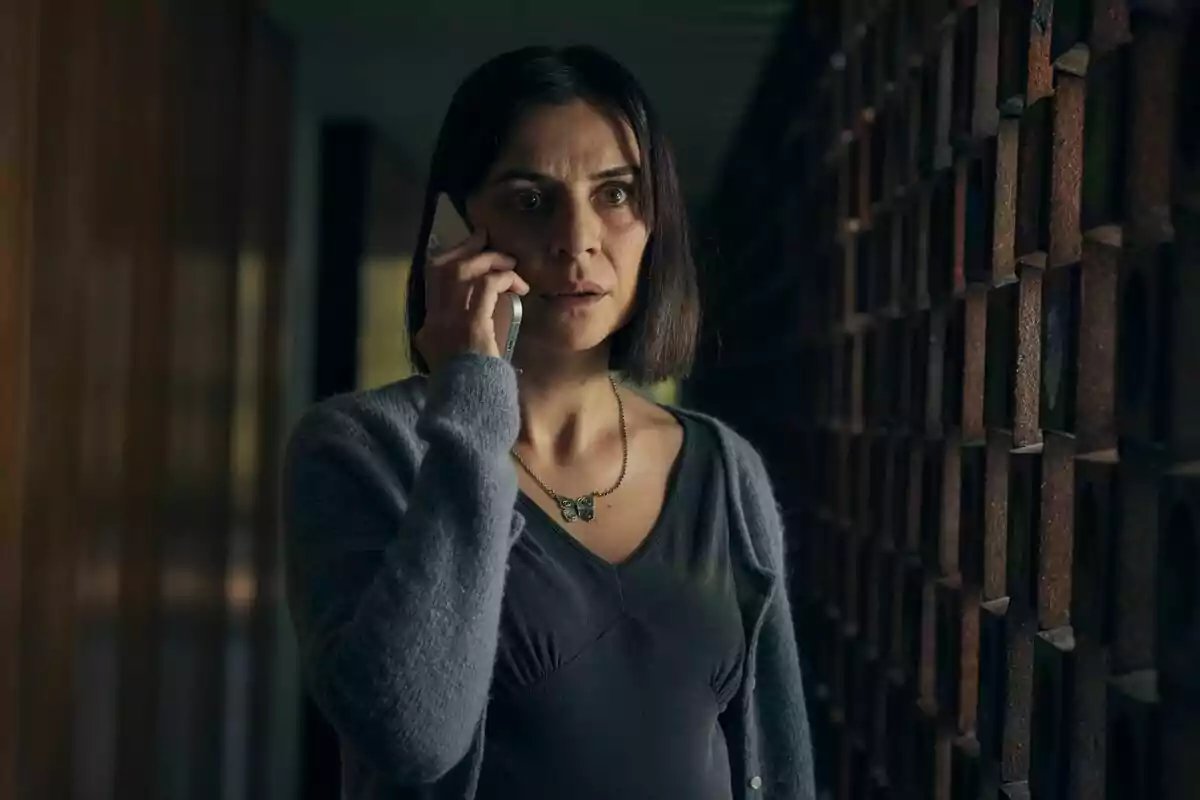 Miren Ibarguren con expresión seria hablando por teléfono en un pasillo oscuro en Los sin nombre.