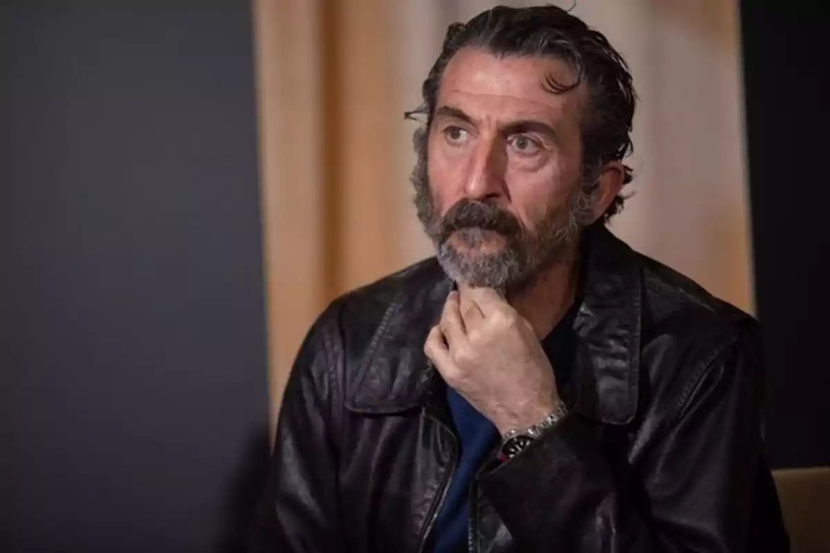 Luis Zahera amb jaqueta de cuir i barba, pensatiu, amb la mà al mentó. Luis Zahera amb jaqueta de cuir i barba, pensatiu, amb la mà al mentó.
