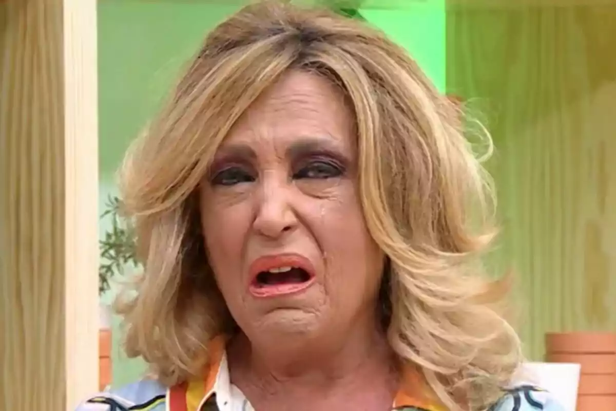Lydia Lozano rubia con expresión de disgusto y lágrimas en el rostro en un entorno interior colorido en La Familia de la Tele.