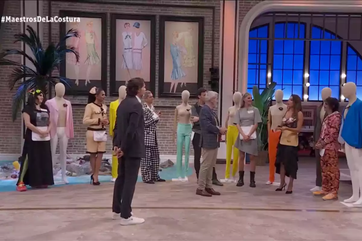 Un grup de persones està reunit en un estudi de televisió, envoltats de maniquins i decoracions acolorides, mentre observen atentament una presentació o activitat. Captura de 'Maestros de la Costura'. Un grup de persones està reunit en un estudi de televisió, envoltats de maniquins i decoracions acolorides, mentre observen atentament una presentació o activitat. Captura de 'Maestros de la Costura'.