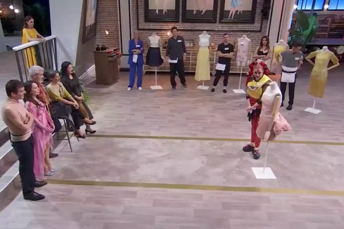 Un grupo de personas observa a Terre que sostiene un maniquí en un estudio de diseño de moda en 'Maestros de la Costura Celebrity'. Un grupo de personas observa a Terre que sostiene un maniquí en un estudio de diseño de moda en 'Maestros de la Costura Celebrity'.