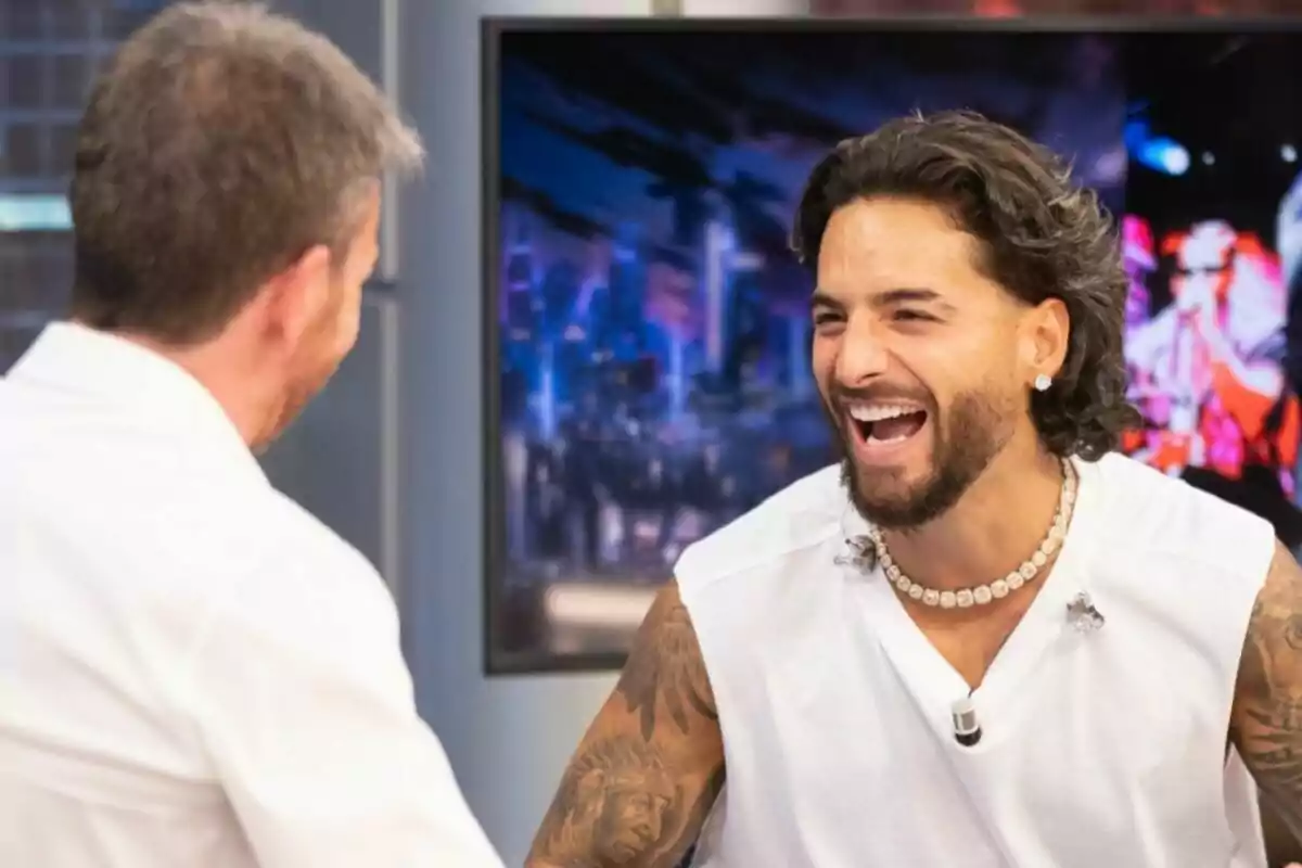 Maluma con Pablo Motos conversando y riendo en El Hormiguero con un fondo colorido. Maluma con Pablo Motos conversando y riendo en El Hormiguero con un fondo colorido.